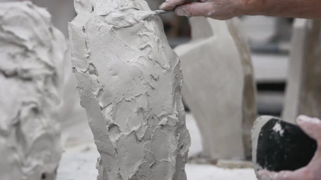 Mold maker using plaster to make mold in workshop.