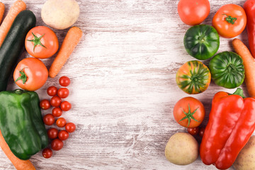 Top view of delicious fresh and healthy raw vegetables placed to leave a space for text or an image. Rustic white wood background. Copy space. Healthy food. Natural products. Nature and well-being