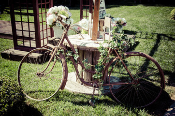Fototapeta na wymiar bicicleta antigua decorada con flores para boda efecto vintage