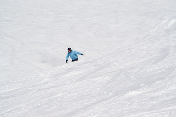 Fototapeta na wymiar Snowboarder before jump on snowy ski slope at high winter mountains