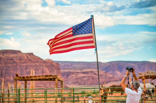 Male photographer taking pictures of american flag in the national park