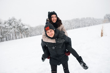 Fototapeta na wymiar Couple in love walking in the snowy woods