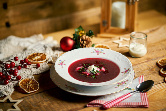 Traditional christmas red borscht on wooden table