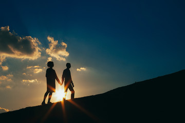 Couple in love at sunset rises up the hill