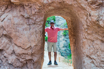 Fototapeta na wymiar Happy man visiting national park embracing natural arch