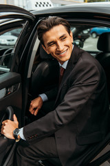 Smiling businessman getting out of taxi and looking away © LIGHTFIELD STUDIOS