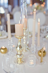 Golden candlesticks with burning candles. Luxury table setting