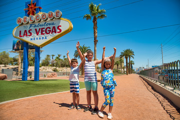 Three young children enjoy Las Vegas at famous city entrance sign