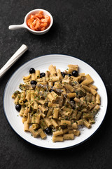 pasta with blueberry and dry shrimp on black background