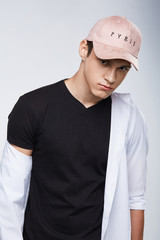 Cropped front view shot of a dark-haired man, wearing pink baseball cap with lettering 
