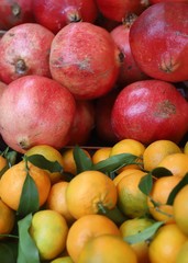 closeup of mandarins with pomegranate background on display at the market