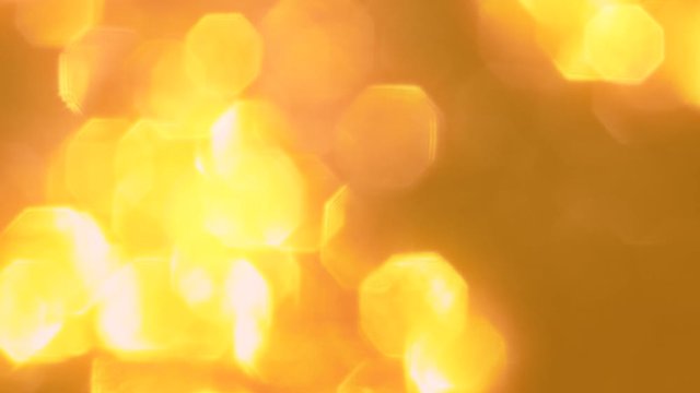 Golden sparkles. Shiny spangles. Blur yellow glowing sequins pattern background.