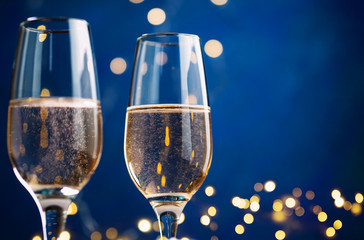 The celebration of Christmas 2020 . Festive glass of champagne on blue background copy space