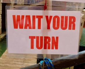 Wait Your Turn sign in red lettering