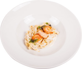 Handmade creamy pasta cooked on a shrimp biscuit, flavored with lemon pepper. Served with tiger prawns fried in aromatic herbs on white plate.