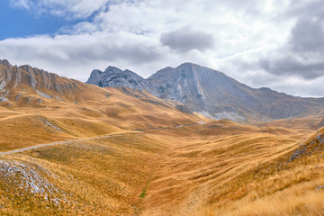 Rocky mountains covered with autumn meadow against the background of a stormy sky