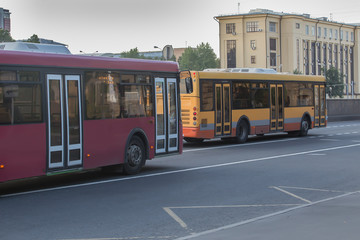 Fototapeta na wymiar Regular buses move along a street