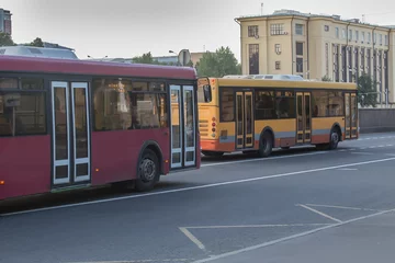 Foto op Canvas Regular buses move along a street © Yuri Bizgaimer
