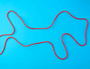 fragment of a red jump rope for sports on a blue background