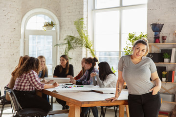 Women's rights and equality at the office. Caucasian businesswomen or young confident model smiling in front of coworkers having meeting about problem in workplace, male pressure and harassment.