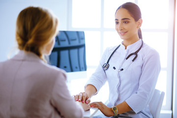 Doctor and patient. Arab woman doctor and patient discussing something while sitting at the table . Medicine and health care concept.