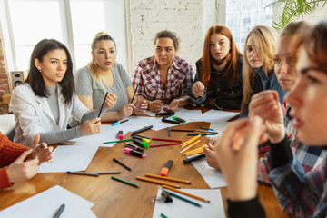 Young women preparing poster about women's rights and equality at the office. Caucasian businesswomen or office workers have meeting about problem in workplace, male pressure and harassment.