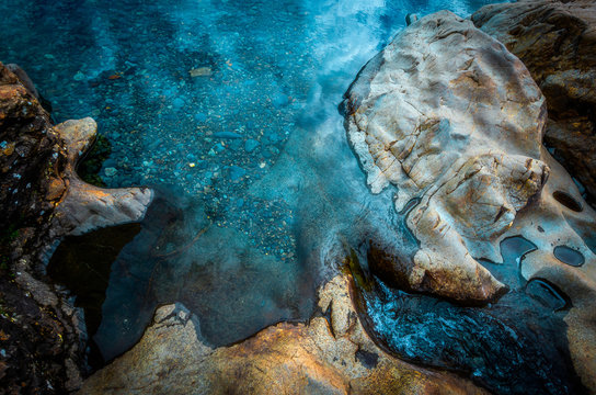 Turquoise water flowing among rocks at fairy pools on Isle of Skye, Scotland,UK.View from above.Nature abstract with vibrant colors.Landscape details.Beauty of natural world.