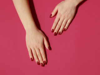 Manicure in a trandy dark red color on a red background. Flat lay style. - obrazy, fototapety, plakaty