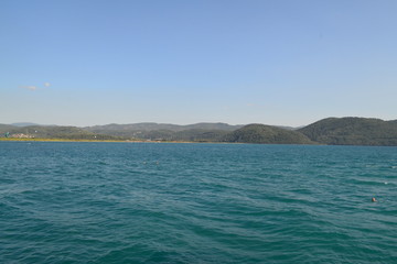 Naklejka premium The sea captured from the seaside, there are hills and blue sky. Captured in daytime.