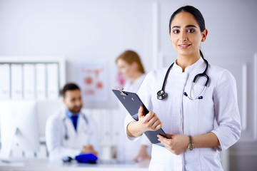 Arabian Doctor standing in Front of her team in the hospital