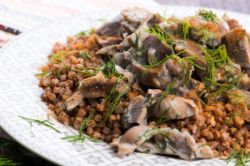 Stewed turkey stomachs with vegetables and buckwheat in a bowl