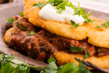 Potato pancakes with meat, vegetable, tomato and parsley