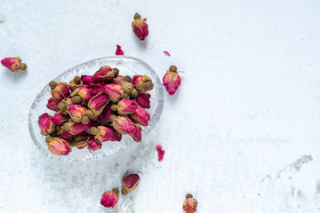 dried rose buds tea in a glass bowl.