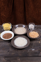 Ingredients and kitchen utensils for cooking various side dishes and porridge on a wooden table