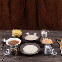 Ingredients and kitchen utensils for cooking various side dishes and porridge on a wooden table