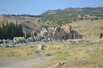 Obraz premium Old Hierapolis ruins, amphitheatre and touristic locations captured with hill background, in daytime.