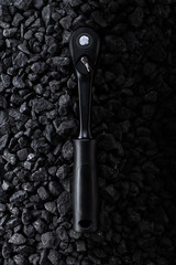Professional reinforced black matt hex wrench placed on a stony background. View from the top.