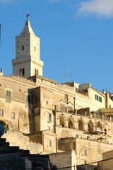 Houses and bell tower in the city of Matera in Italy. The tuff blocks are the material used for the construction of the houses.