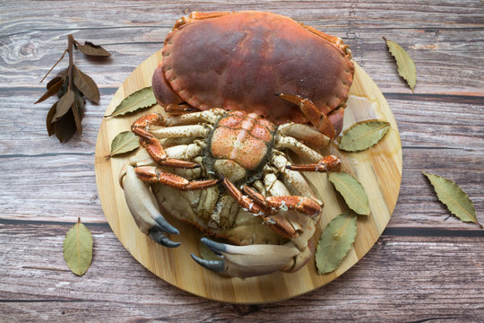 Cooked big crabs with bay leaves on a wooden table