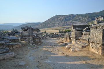 Old Hierapolis ruins, amphitheatre and touristic locations captured with hill background, in daytime.