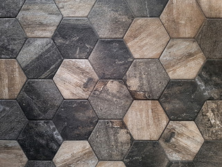 The texture of the ceramic tiles in the form of a hexagon made of brown natural stone. Concept texture, background.