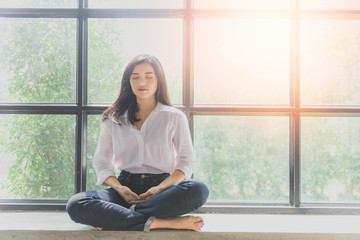 Portrait of calm Asian girl meditation in the morning. Young woman indoors Living lifestyle at home.