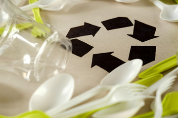 Single use, Disposable tableware and recycling sign on background. Spoons, forks. Plastic pollution, waste. Plastic processing problem and ecological material, eco, ecology, recycle. Zero waste