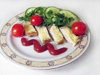 Sliced ​​fish with cherry tomatoes, ketchup and herbs on a plate.