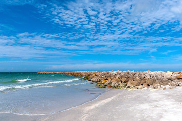 Breakwater rock barrier at the end of Bell Air beach, Florida, on a sunny and warm morning.