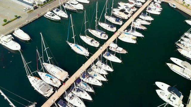 Aerial, marina full of sailboats and yachts, tilt down backward shot. Location Marina di Riposto, Sicily.