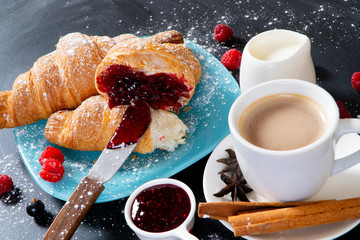 Croissant with fresh berries, chocolate spread and butter with cup of coffee
