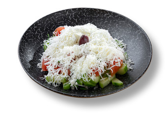 Fresh salad with tomatoes and white cheese in modern black plate