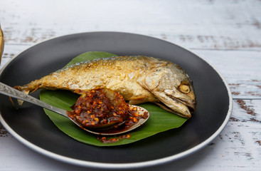 mackerel Thai food Deep friedis on a black plate.