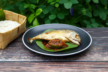 mackerel Thai food Deep friedis on a black plate.